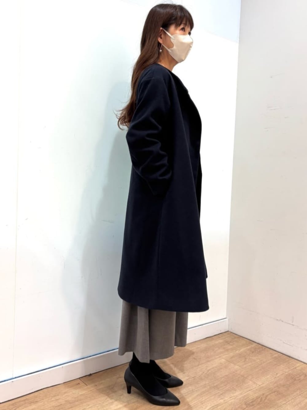 グレー系のその他パンツ、グレー系のニット/セーター、ブルー系のノーカラーコートを着用したレディースの秋コーディネートの2枚目の写真