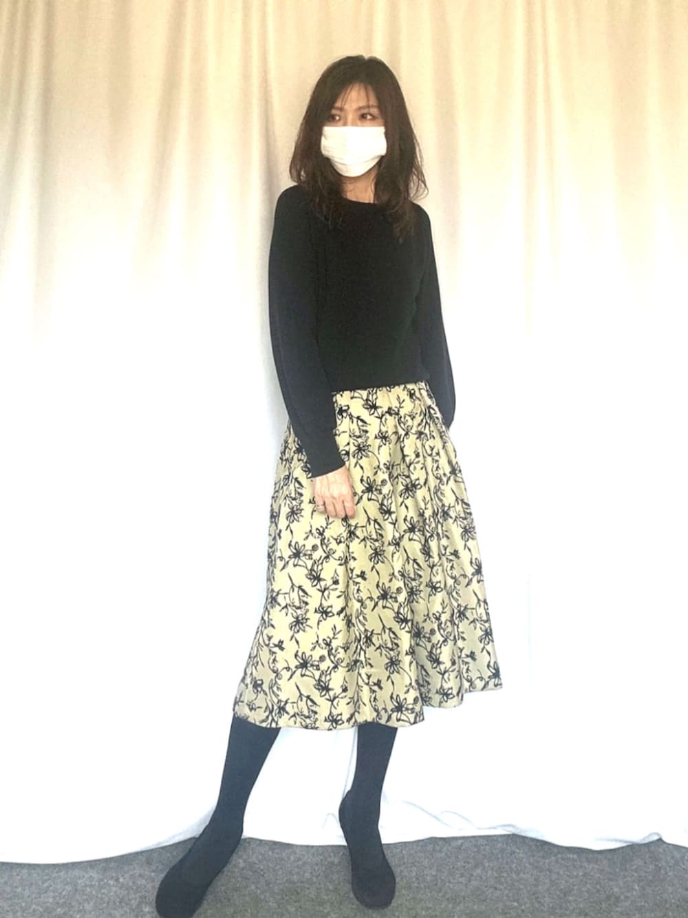 ブラック系のニット/セーター、グリーン系のスカートを着用したレディースの秋コーディネートの2枚目の写真