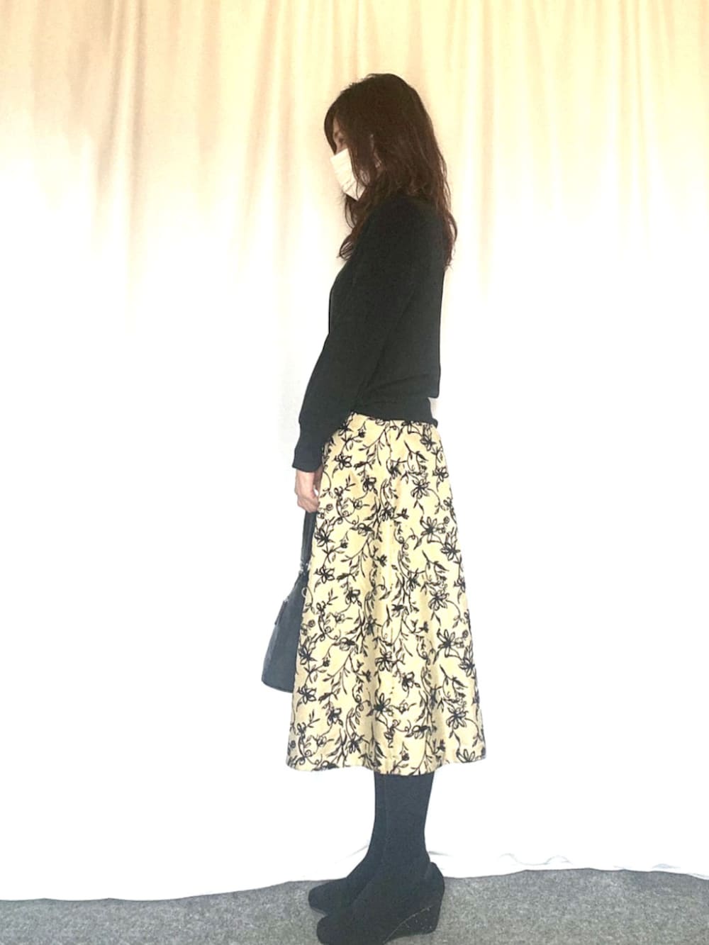 ブラック系のニット/セーター、グリーン系のスカートを着用したレディースの秋コーディネートの3枚目の写真