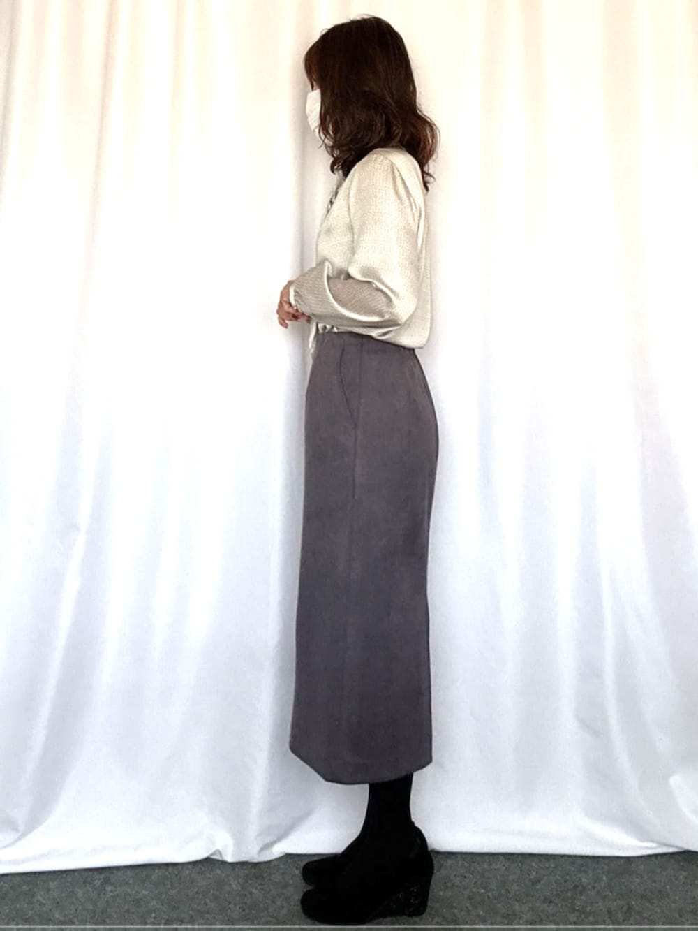 グレー系のスカート、ホワイト系のシャツ/ブラウスを着用したレディースの秋コーディネートの2枚目の写真