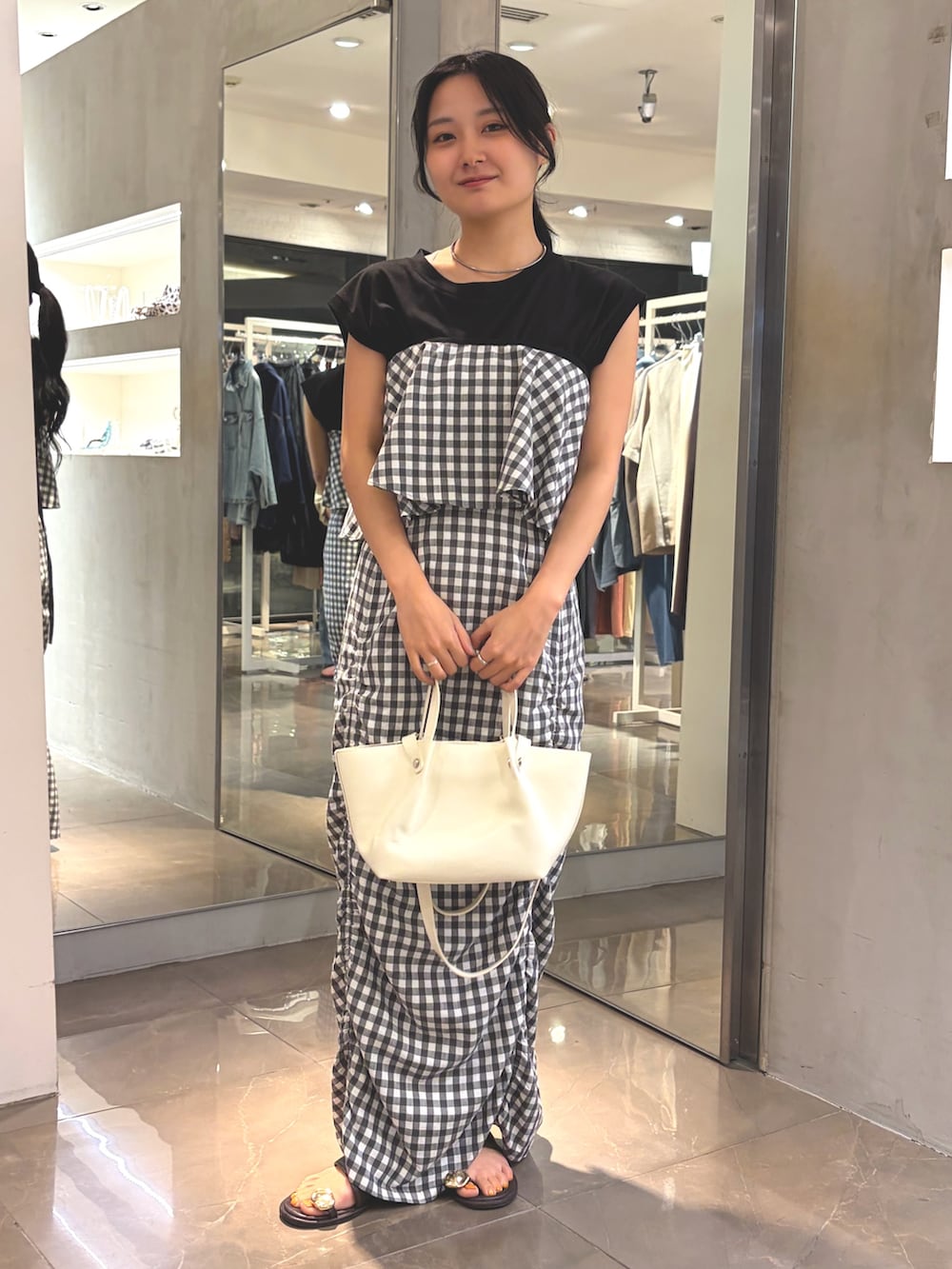 グレー系のスカート、ホワイト系のショルダーバッグ、ブラウン系のサンダルを着用したレディースの夏コーディネートの6枚目の写真