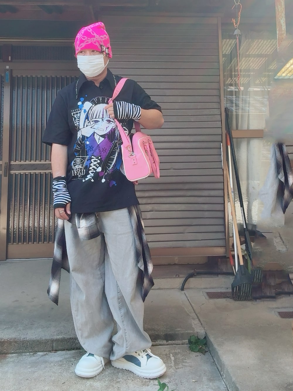 ブラック系のTシャツ/カットソー、ホワイト系のスニーカー、ピンク系のボストンバッグを着用したメンズの夏コーディネートの2枚目の写真