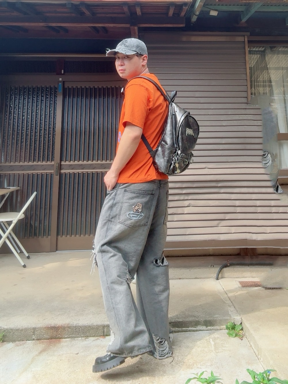 ブラック系のデニムパンツ、ブラック系のローファー、グレー系のキャップを着用したメンズの夏コーディネートの2枚目の写真