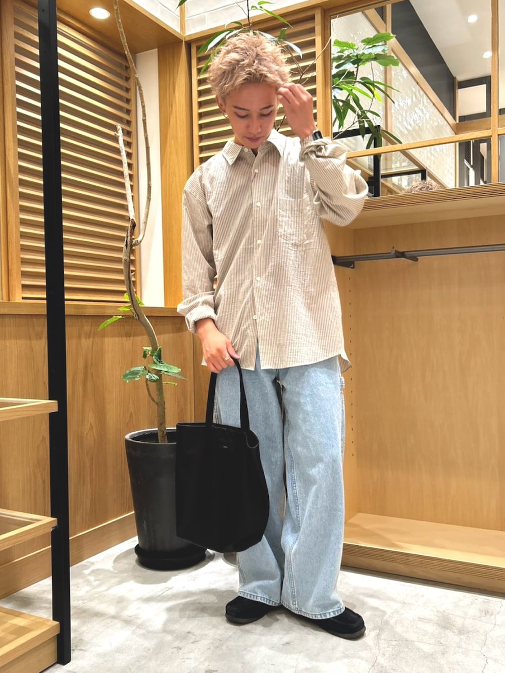 ベージュ系のシャツ/ブラウス、ブルー系のデニムパンツ、ブラック系のトートバッグを着用したメンズの秋コーディネートの2枚目の写真