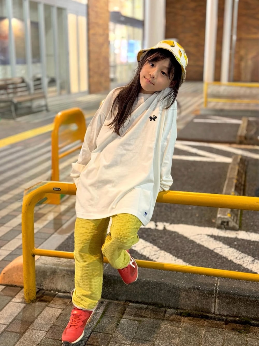 ホワイト系のトップス、イエロー系のパンツ、ホワイト系のハットを着用したキッズの秋コーディネートの4枚目の写真