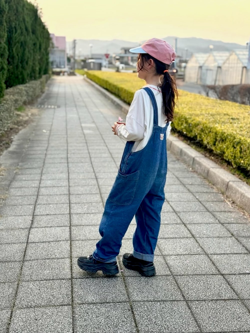 ホワイト系のTシャツ/カットソー、ブルー系のサロペット/オーバーオール、ピンク系のキャップを着用したキッズの夏コーディネートの2枚目の写真