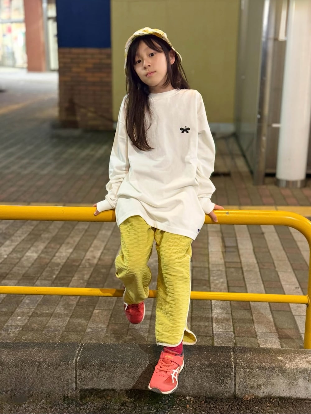 ホワイト系のトップス、イエロー系のパンツ、ホワイト系のハットを着用したキッズの秋コーディネートの3枚目の写真