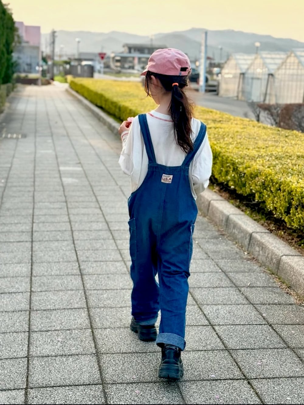 ホワイト系のTシャツ/カットソー、ブルー系のサロペット/オーバーオール、ピンク系のキャップを着用したキッズの夏コーディネートの3枚目の写真