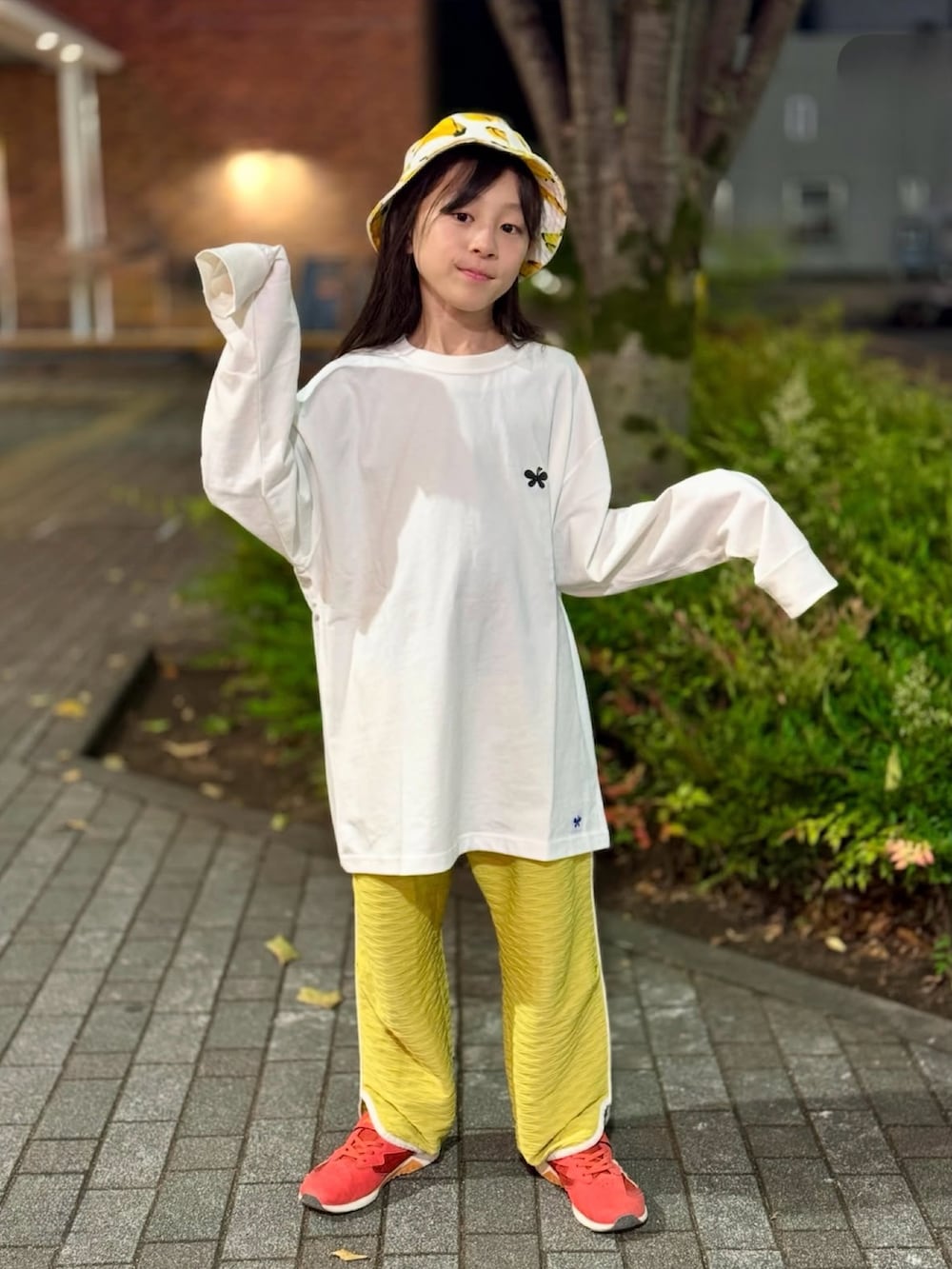 ホワイト系のトップス、イエロー系のパンツ、ホワイト系のハットを着用したキッズの秋コーディネートの5枚目の写真
