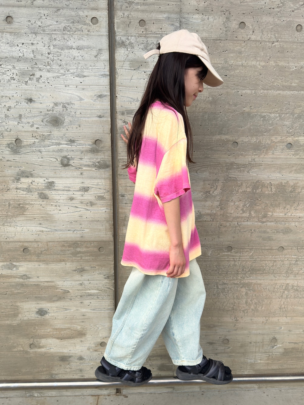 ブラック系のサンダル、ピンク系のTシャツ/カットソー、ブルー系のデニムパンツを着用したキッズの夏コーディネートの2枚目の写真
