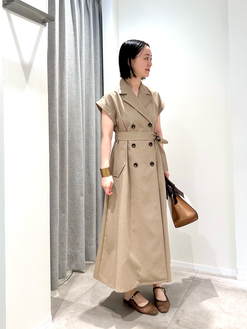 ベージュ系のワンピース、ホワイト系のトートバッグ、ブラウン系のサンダルを着用したレディースの夏コーディネートの4枚目の写真