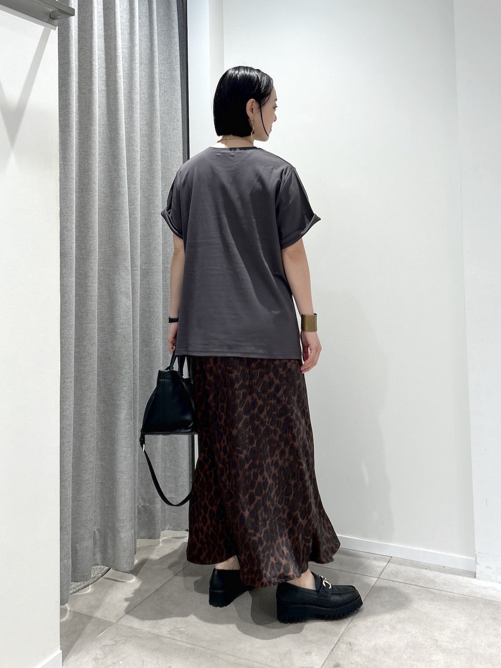 ブラウン系のスカート、グレー系のTシャツ/カットソー、ブラック系のローファーを着用したレディースの夏コーディネートの3枚目の写真