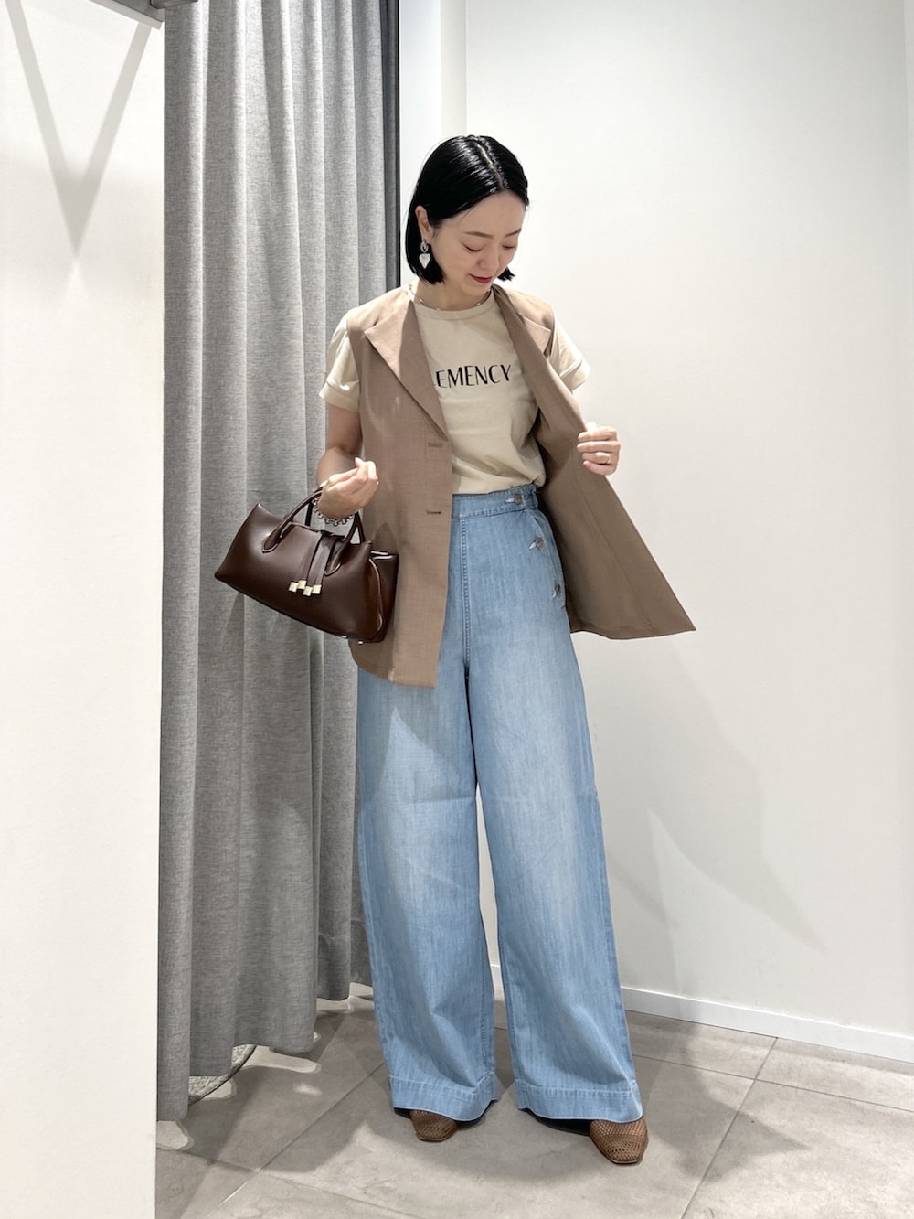 ブラウン系のベスト、ベージュ系のTシャツ/カットソー、ブラウン系のボストンバッグを着用したレディースの夏コーディネートの2枚目の写真