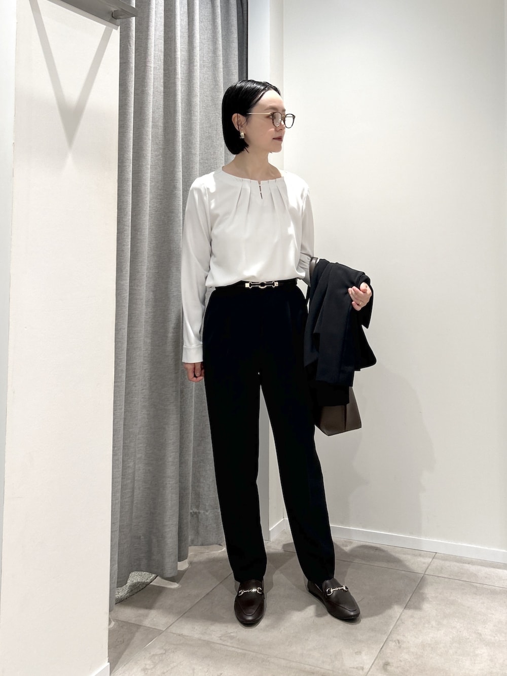 ブラック系のテーラードジャケット、ブラック系のその他パンツ、ブラウン系のトートバッグを着用したレディースの秋コーディネートの2枚目の写真