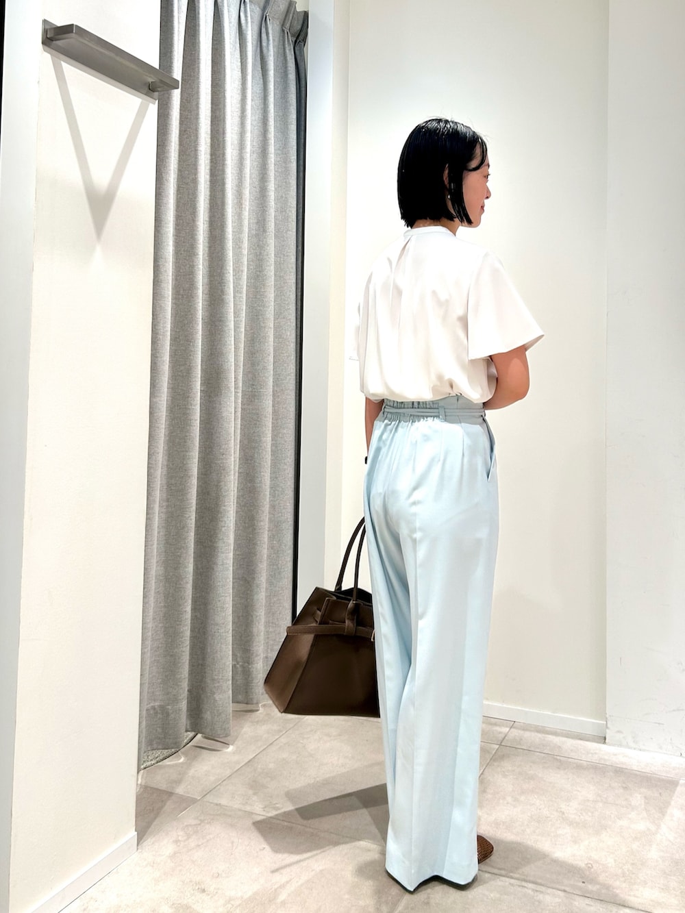 ブルー系のその他パンツ、ブラウン系のトートバッグ、ホワイト系のシャツ/ブラウスを着用したレディースの春コーディネートの2枚目の写真