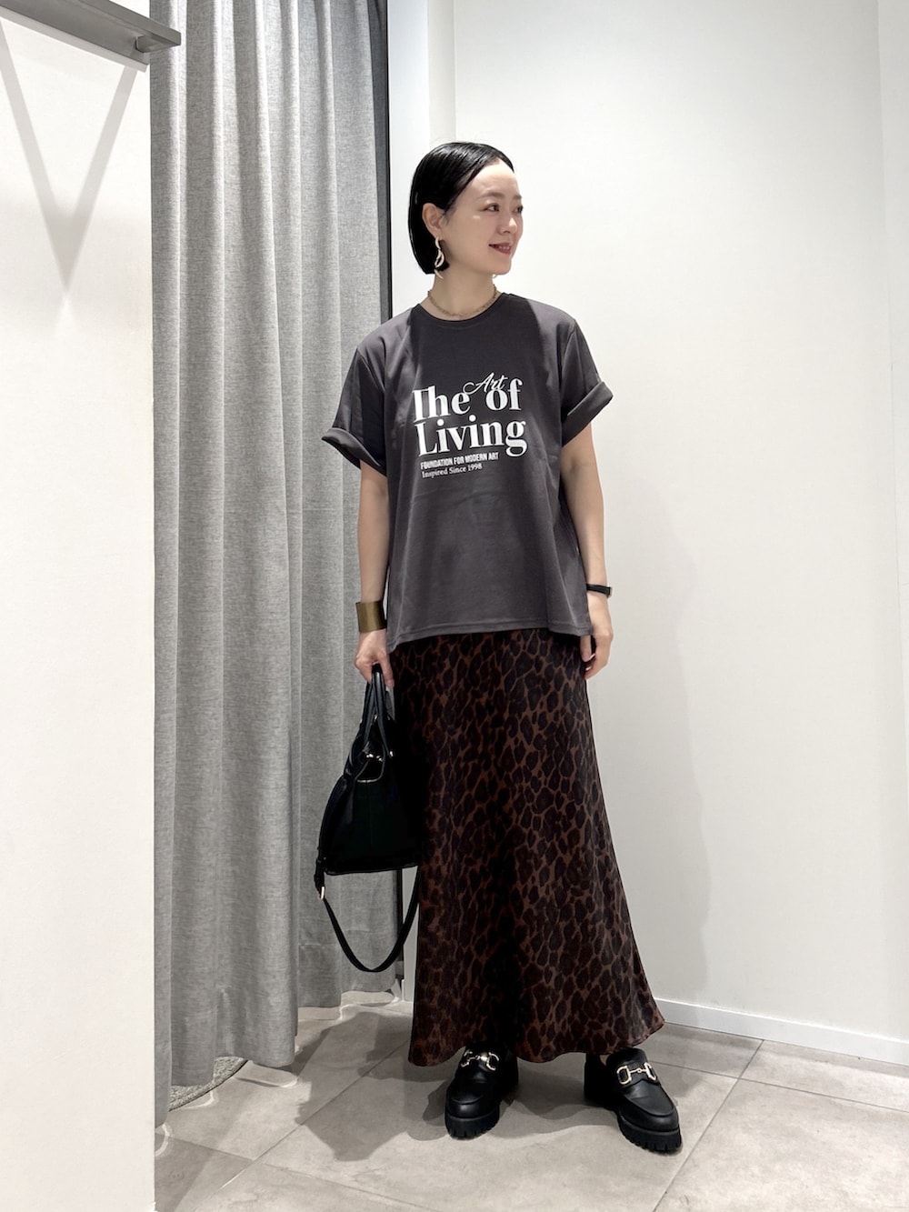ブラウン系のスカート、グレー系のTシャツ/カットソー、ブラック系のローファーを着用したレディースの夏コーディネートの5枚目の写真