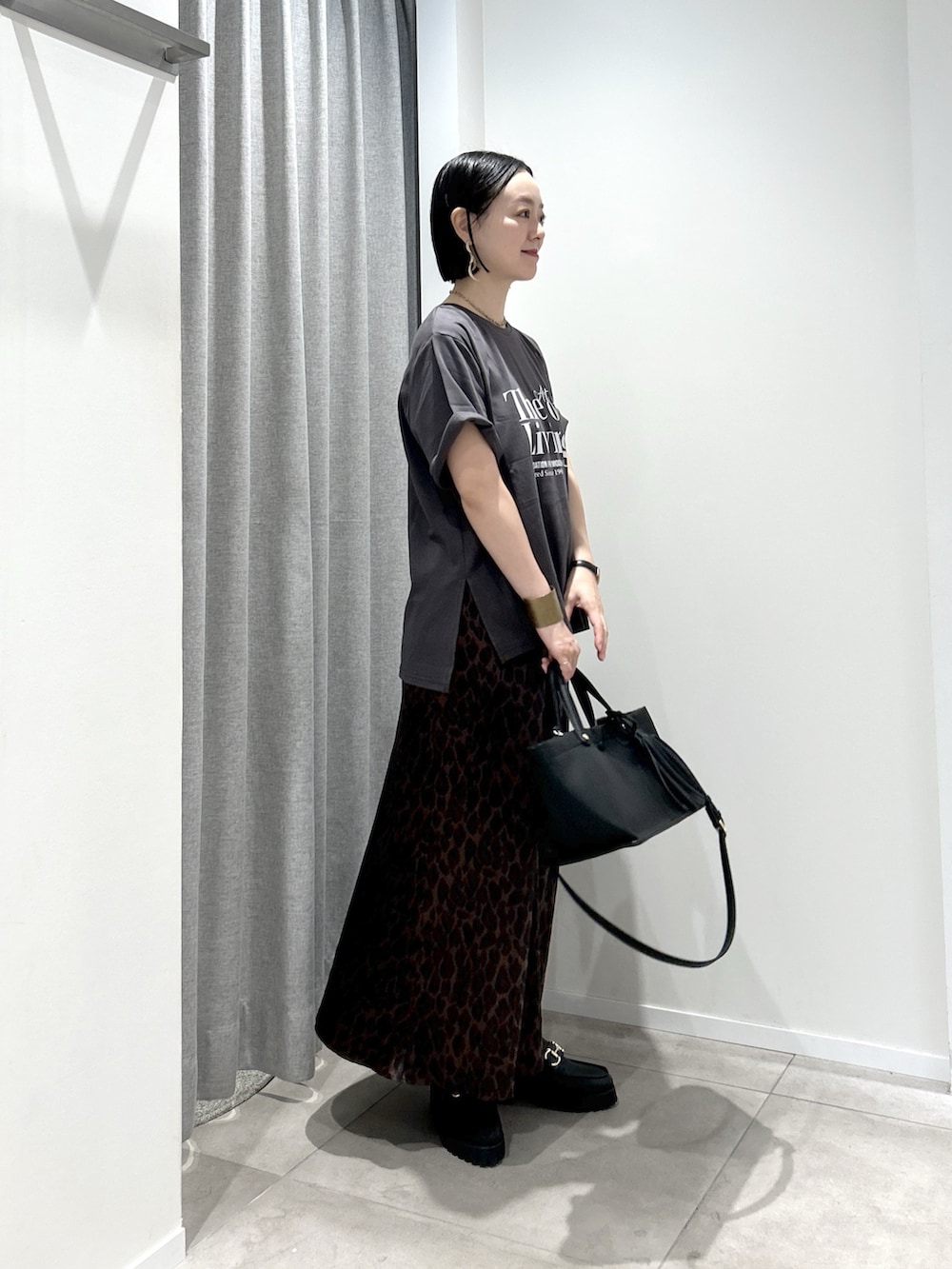 ブラウン系のスカート、グレー系のTシャツ/カットソー、ブラック系のローファーを着用したレディースの夏コーディネートの2枚目の写真