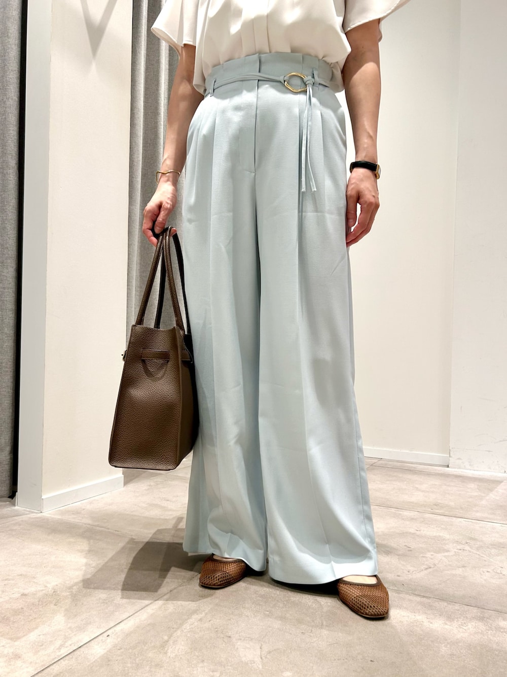 ブルー系のその他パンツ、ブラウン系のトートバッグ、ホワイト系のシャツ/ブラウスを着用したレディースの春コーディネートの5枚目の写真