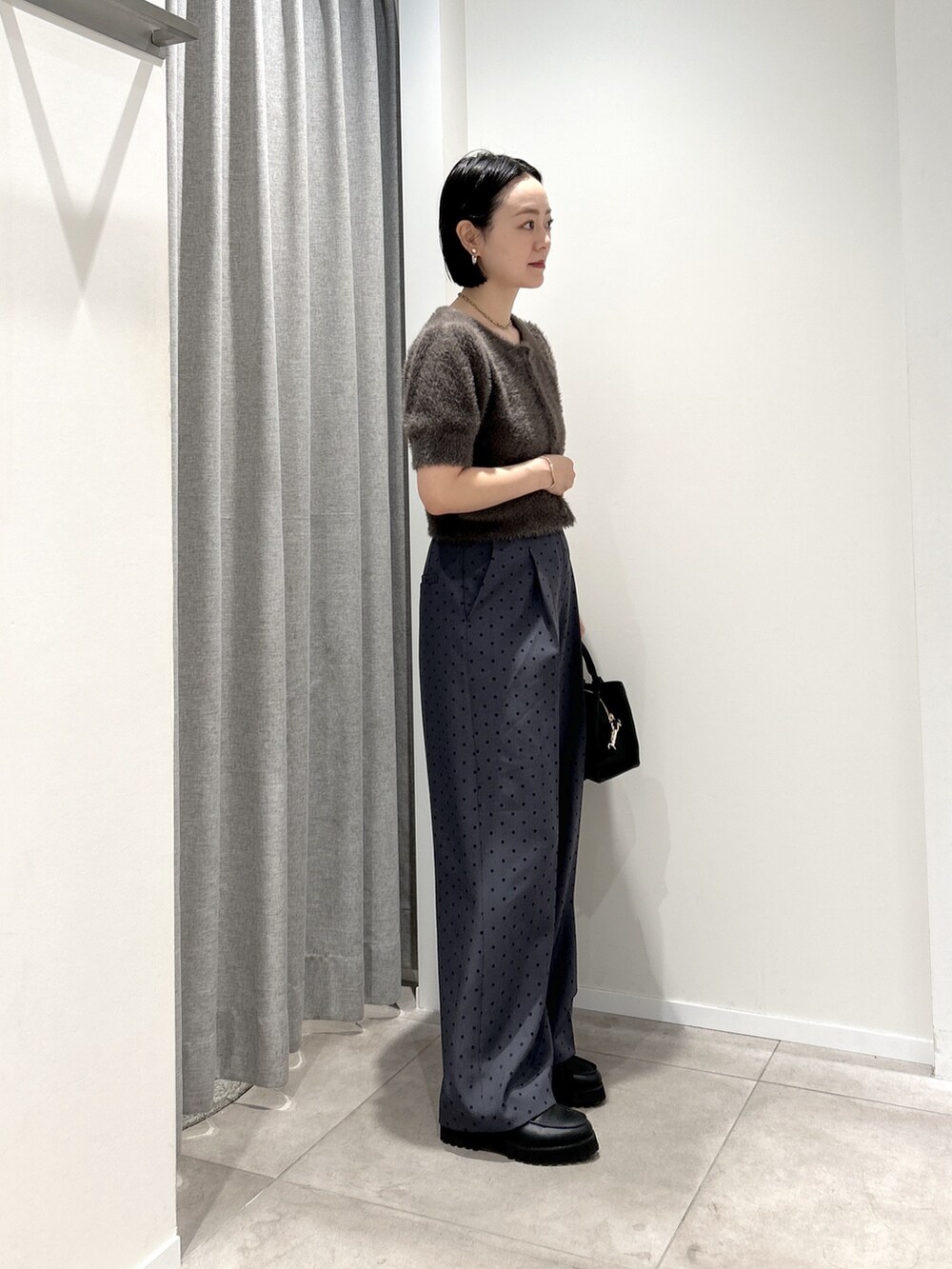 グレー系のその他パンツ、グレー系のニット/セーター、ブラック系のローファーを着用したレディースの夏コーディネートの2枚目の写真