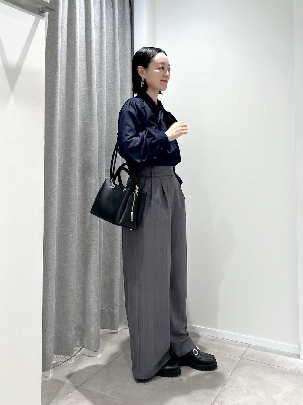 グレー系のその他パンツ、ブルー系のシャツ/ブラウス、ブラック系のトートバッグを着用したレディースの秋コーディネートの2枚目の写真