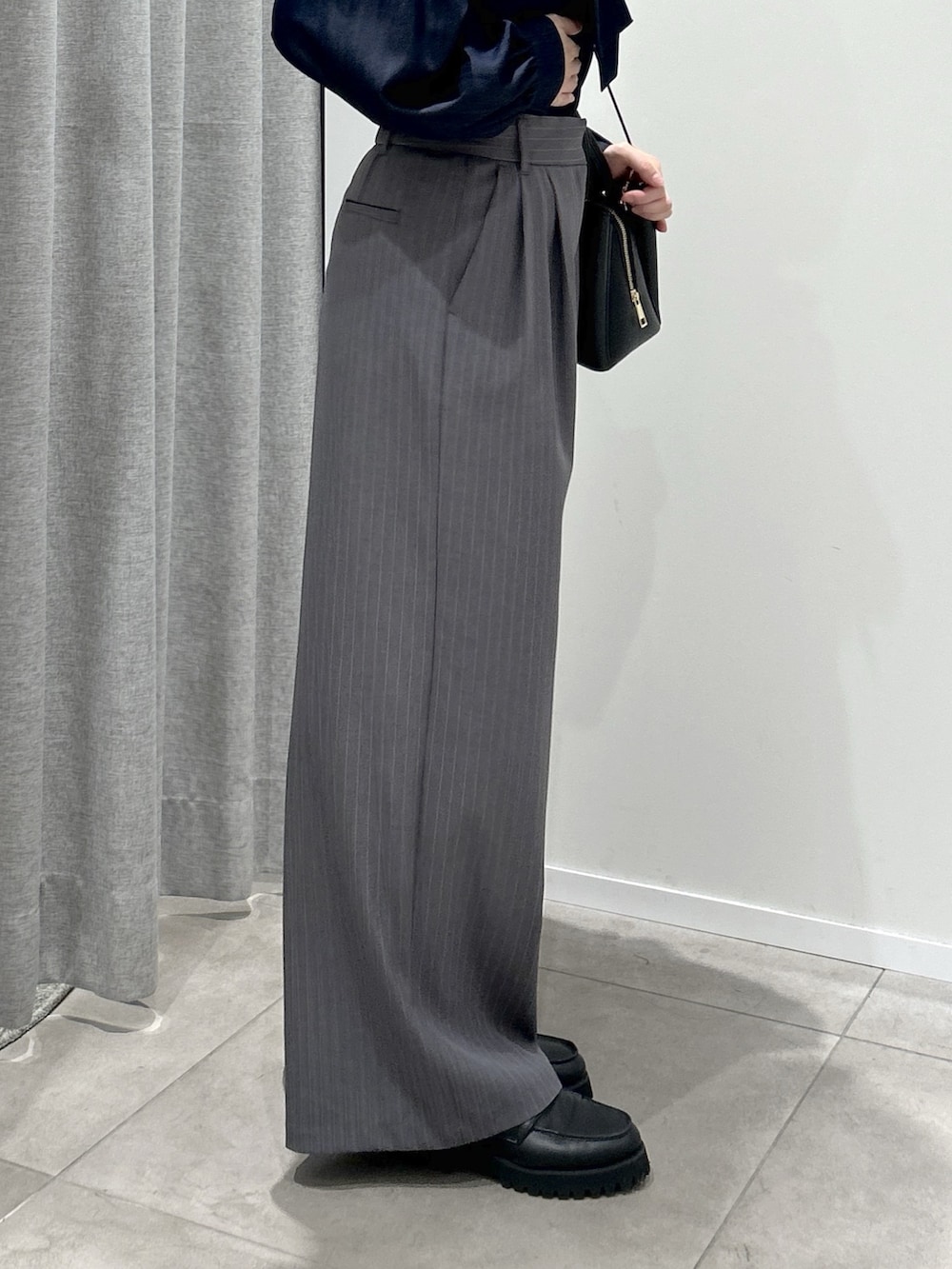 グレー系のその他パンツ、ブルー系のシャツ/ブラウス、ブラック系のトートバッグを着用したレディースの秋コーディネートの3枚目の写真