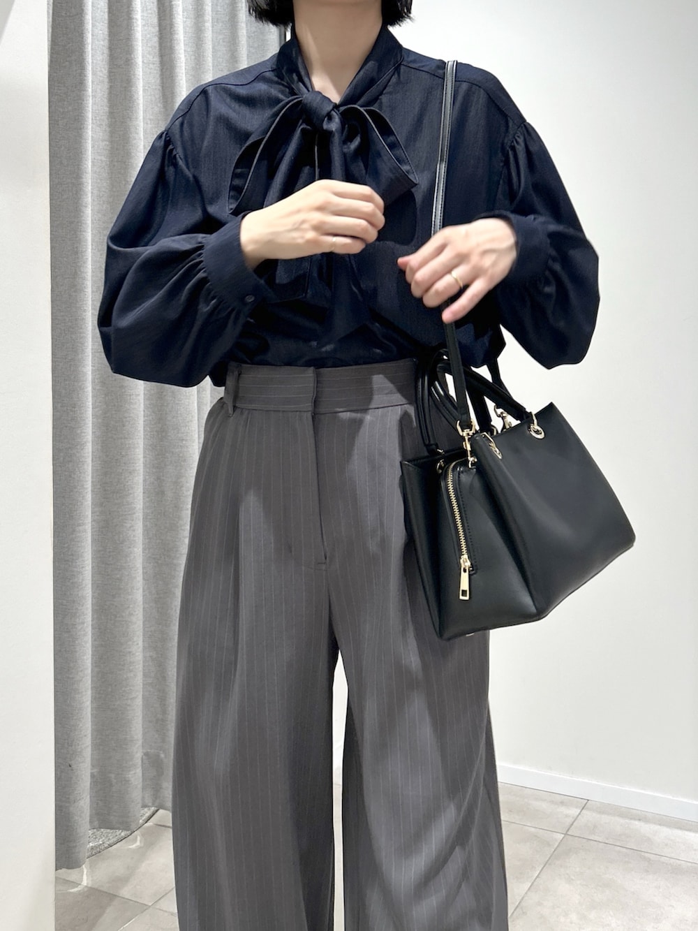 グレー系のその他パンツ、ブルー系のシャツ/ブラウス、ブラック系のトートバッグを着用したレディースの秋コーディネートの5枚目の写真