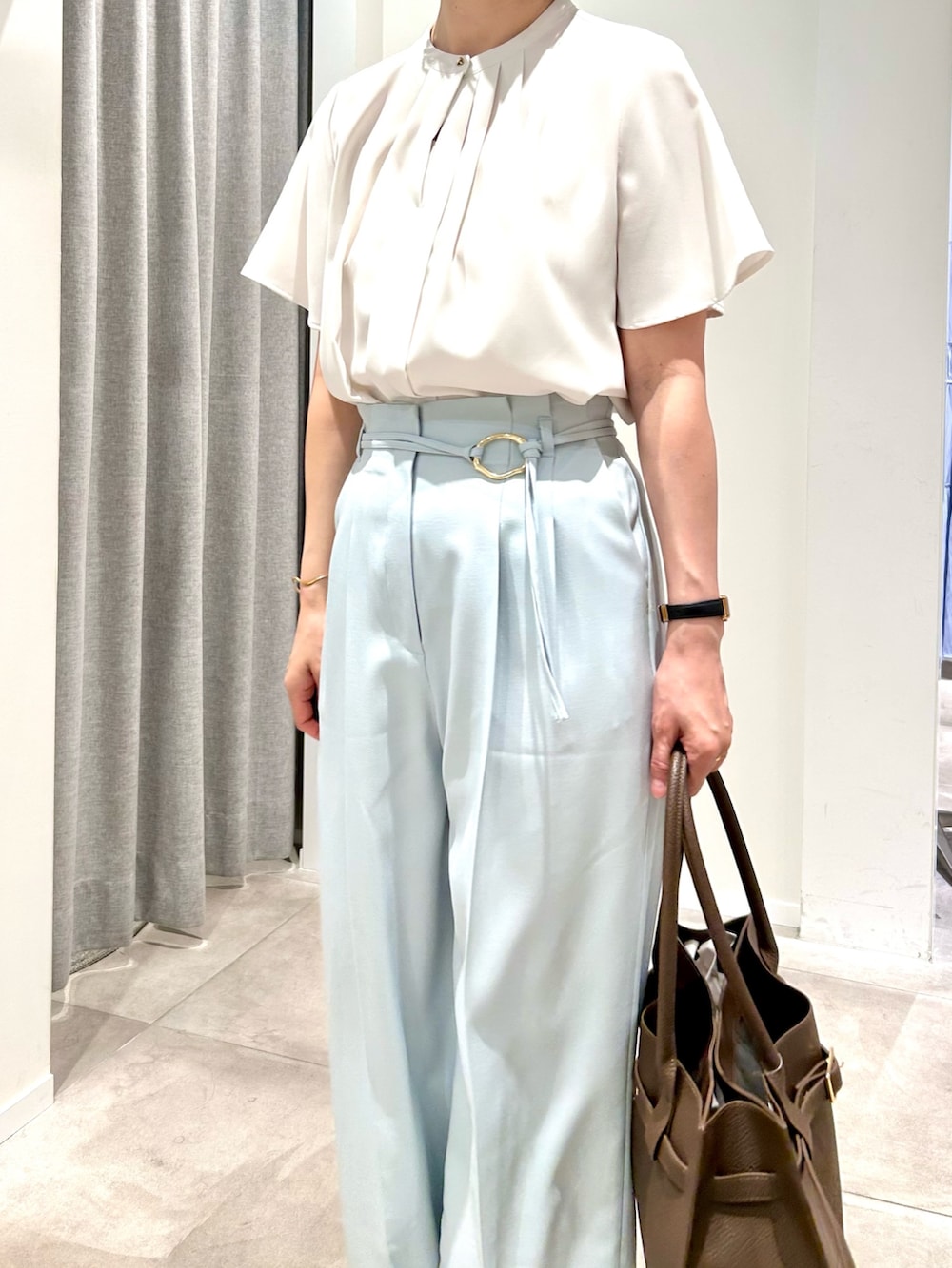 ブルー系のその他パンツ、ブラウン系のトートバッグ、ホワイト系のシャツ/ブラウスを着用したレディースの春コーディネートの3枚目の写真