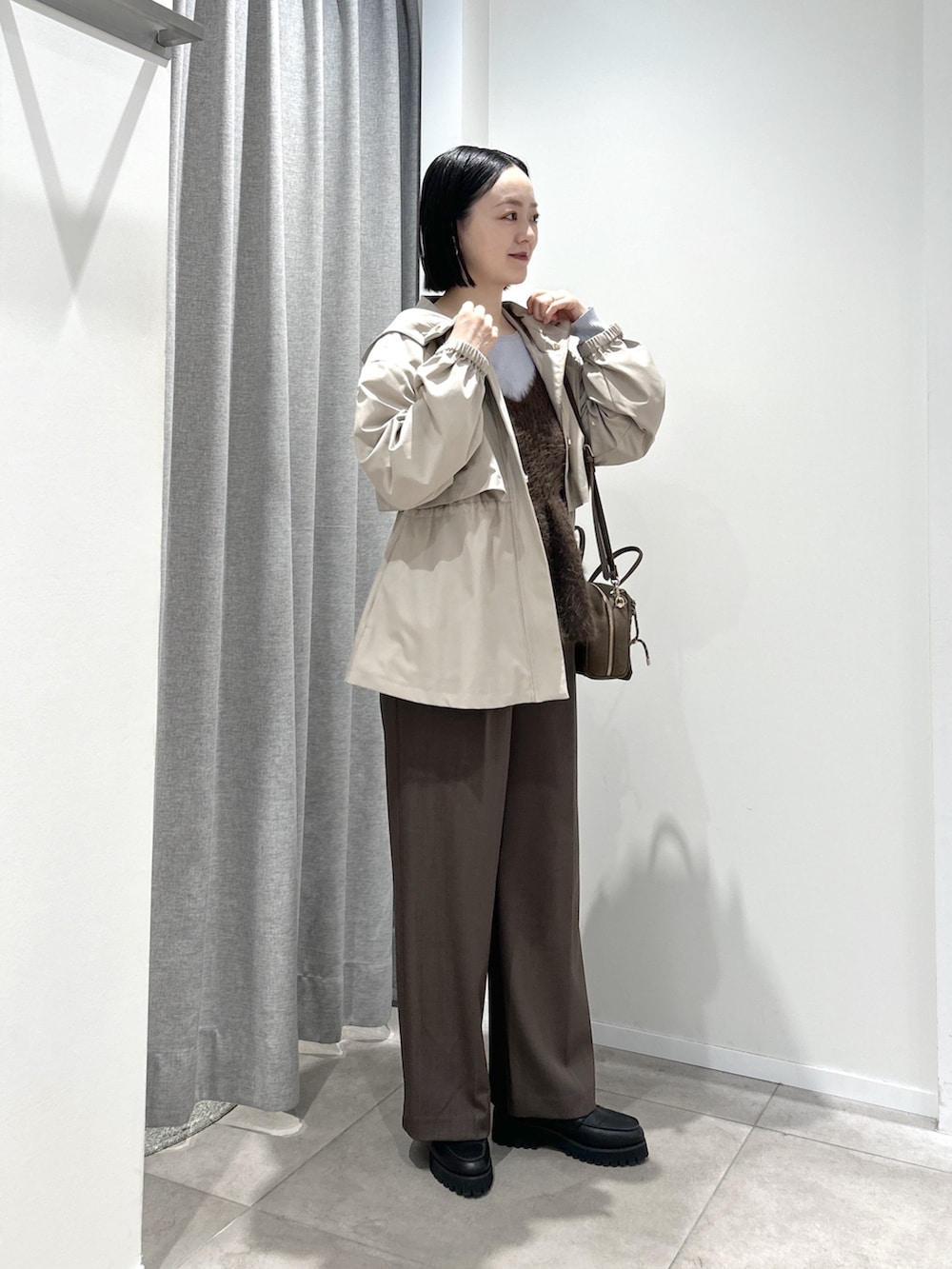 ベージュ系のマウンテンパーカー、ブラウン系のその他パンツ、ブルー系のニット/セーターを着用したレディースの秋コーディネートの3枚目の写真