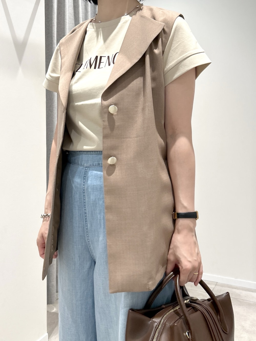 ブラウン系のベスト、ベージュ系のTシャツ/カットソー、ブラウン系のボストンバッグを着用したレディースの夏コーディネートの5枚目の写真