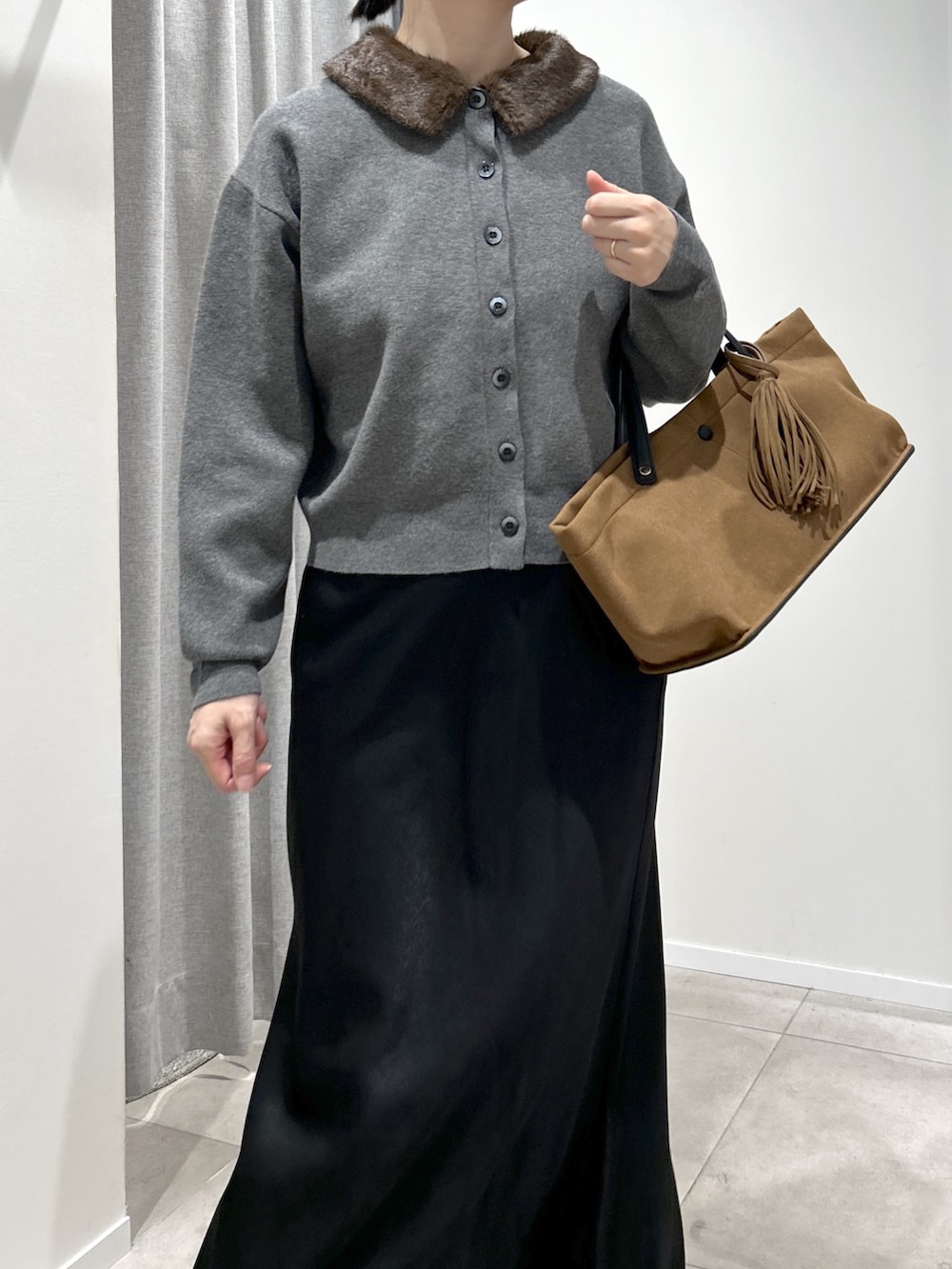 グレー系のカーディガン/ボレロ、ブラック系のスカート、ベージュ系のトートバッグを着用したレディースの秋コーディネートの4枚目の写真