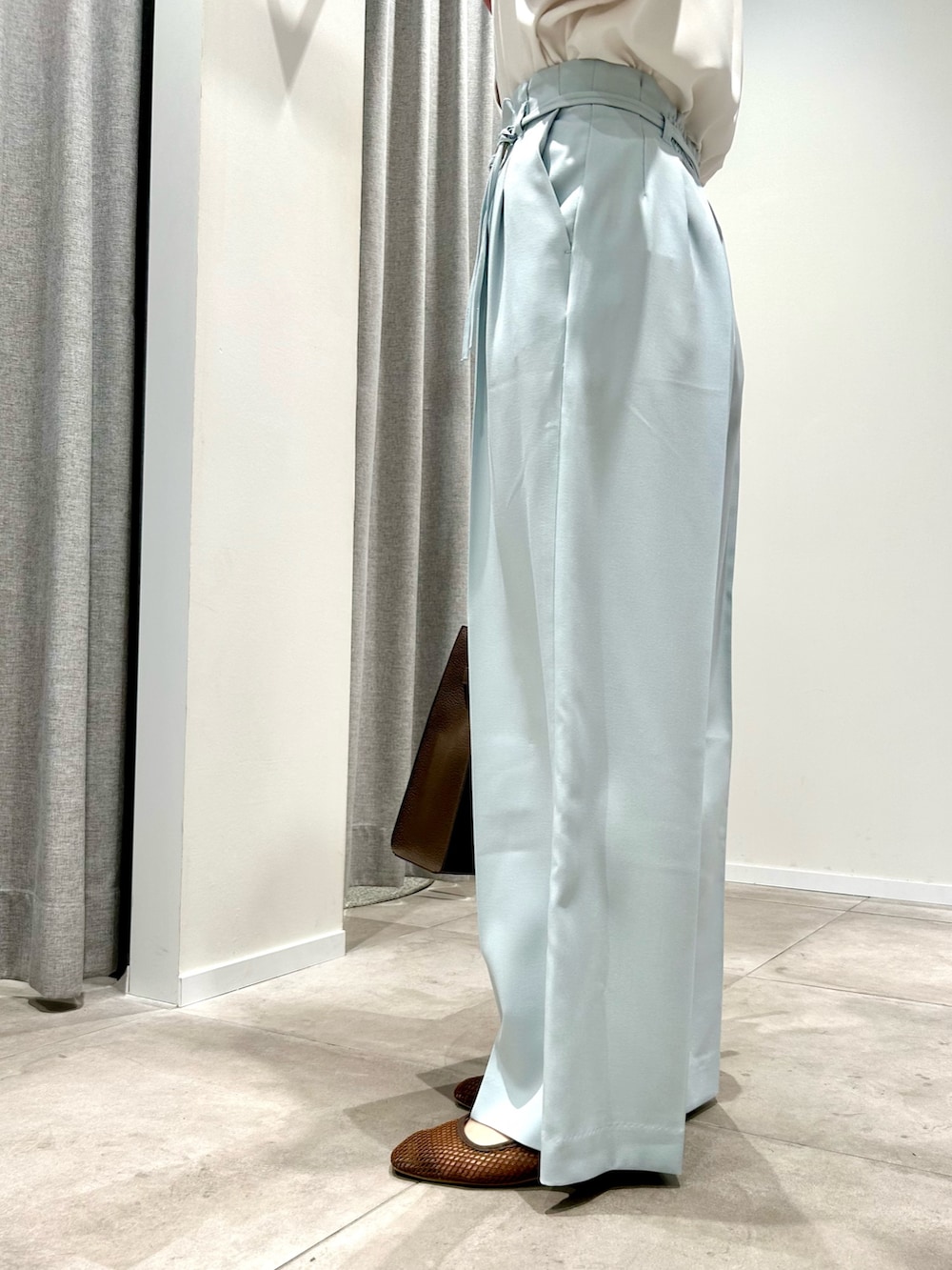 ブルー系のその他パンツ、ブラウン系のトートバッグ、ホワイト系のシャツ/ブラウスを着用したレディースの春コーディネートの4枚目の写真