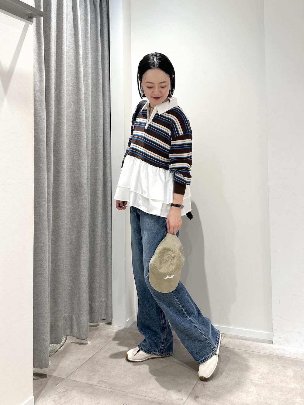 ブルー系のデニムパンツ、ブラック系のバックパック/リュック、ブラウン系のニット/セーターを着用したレディースの秋コーディネートの4枚目の写真