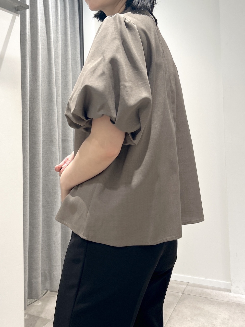 ブラウン系のシャツ/ブラウス、ブラック系のスラックス、ベージュ系のボストンバッグを着用したレディースの夏コーディネートの4枚目の写真