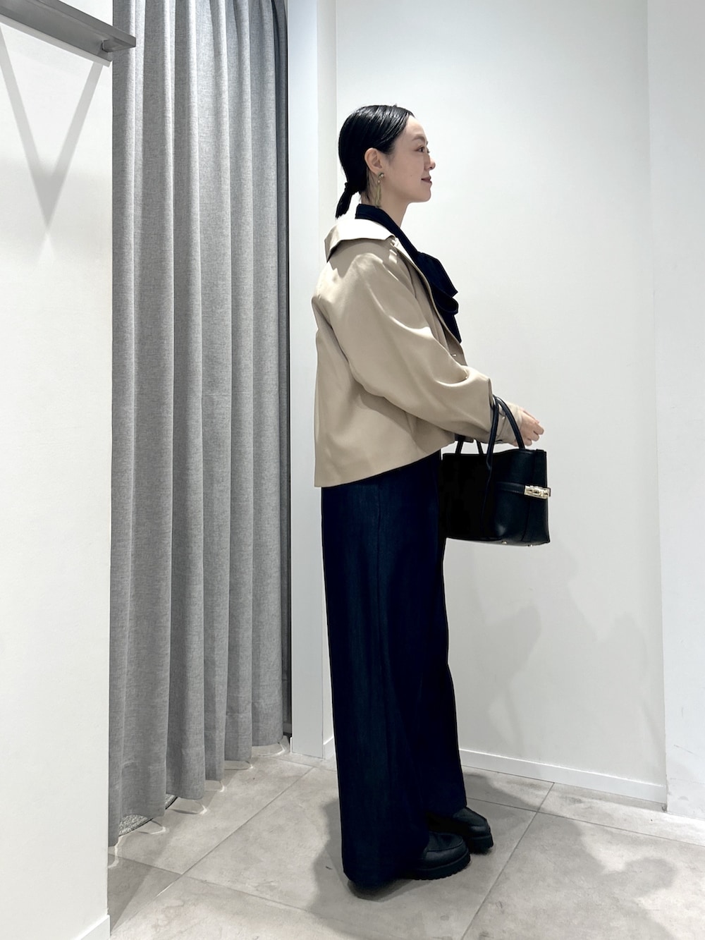 ベージュ系のトレンチコート、ブルー系のシャツ/ブラウス、ブルー系のその他パンツを着用したレディースの秋コーディネートの2枚目の写真