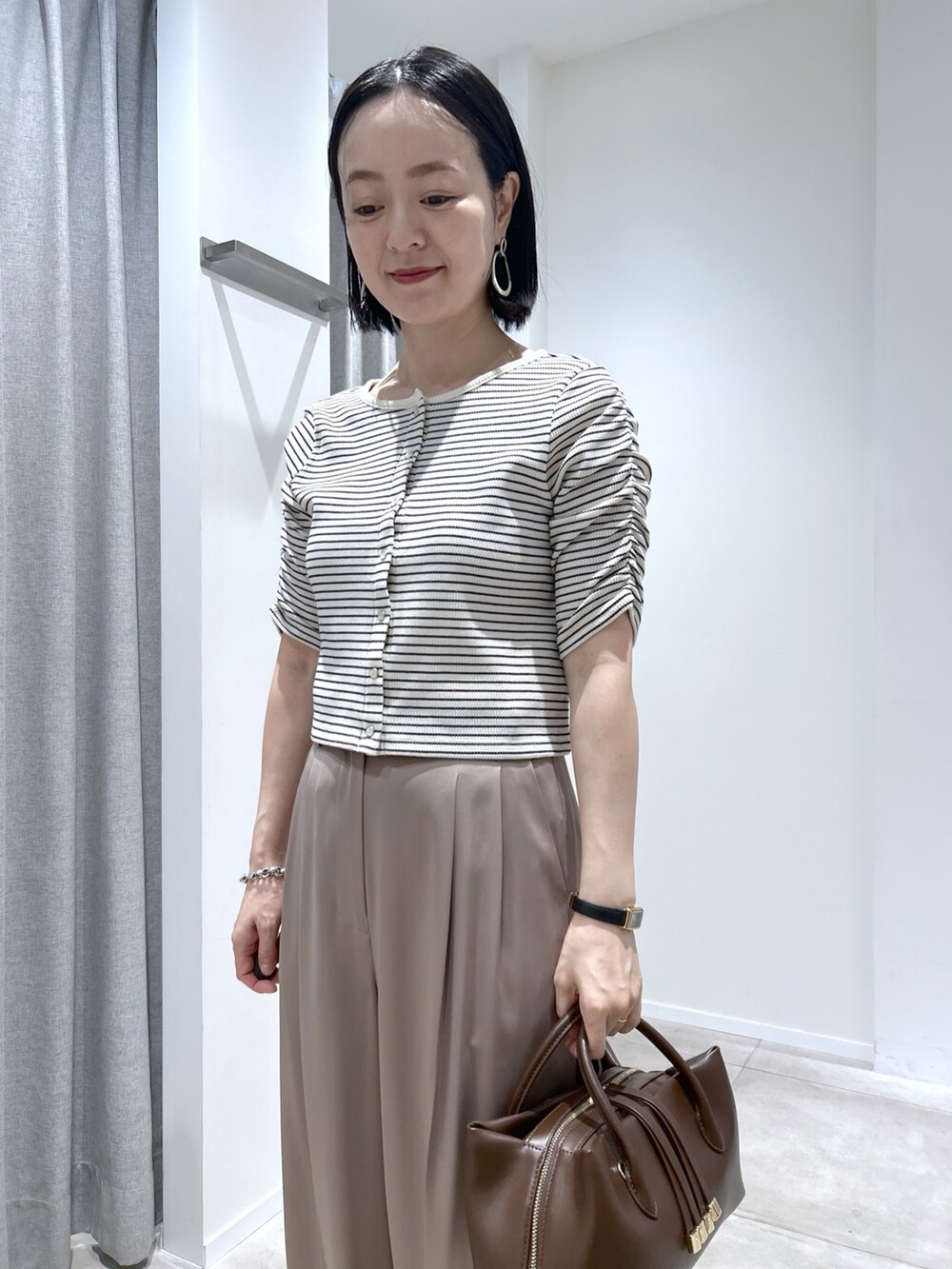 ベージュ系のその他パンツ、ホワイト系のTシャツ/カットソー、ブラウン系のボストンバッグを着用したレディースの夏コーディネートの4枚目の写真