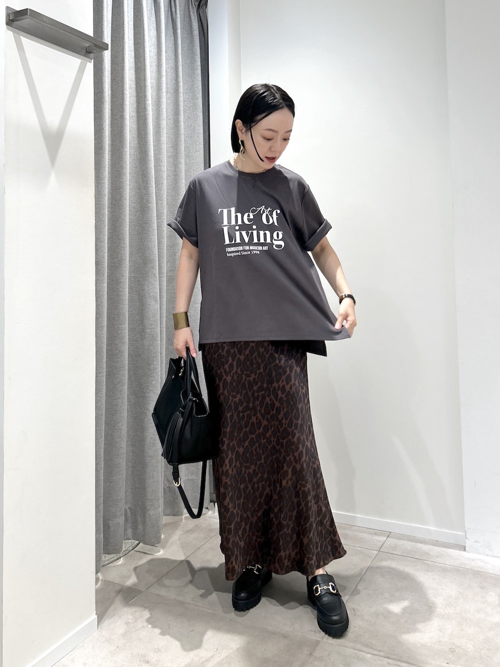 ブラウン系のスカート、グレー系のTシャツ/カットソー、ブラック系のローファーを着用したレディースの夏コーディネートの4枚目の写真