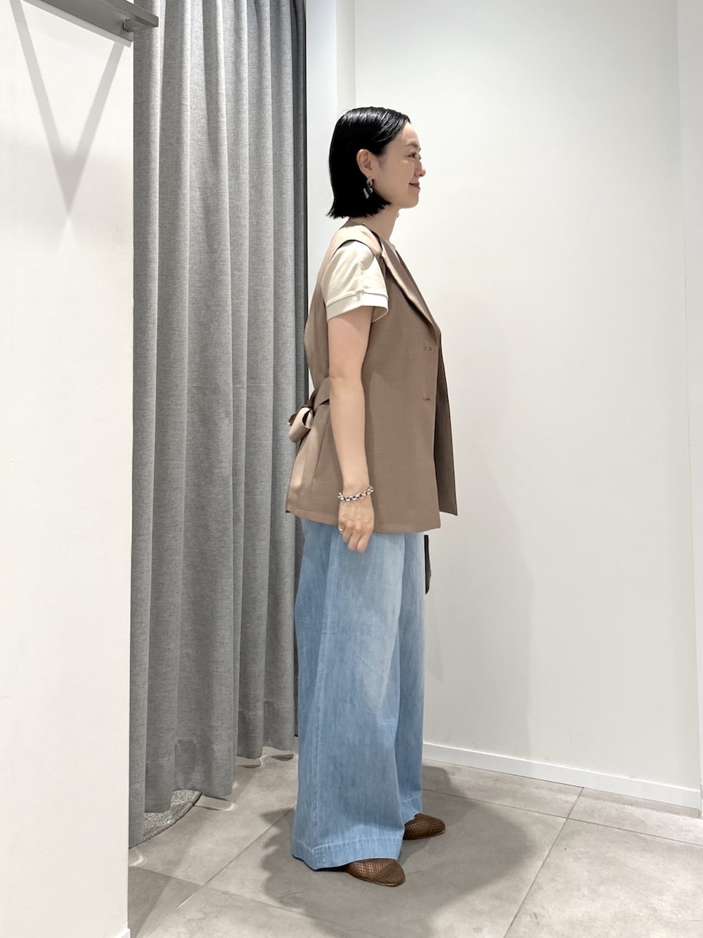 ブラウン系のベスト、ベージュ系のTシャツ/カットソー、ブラウン系のボストンバッグを着用したレディースの夏コーディネートの4枚目の写真