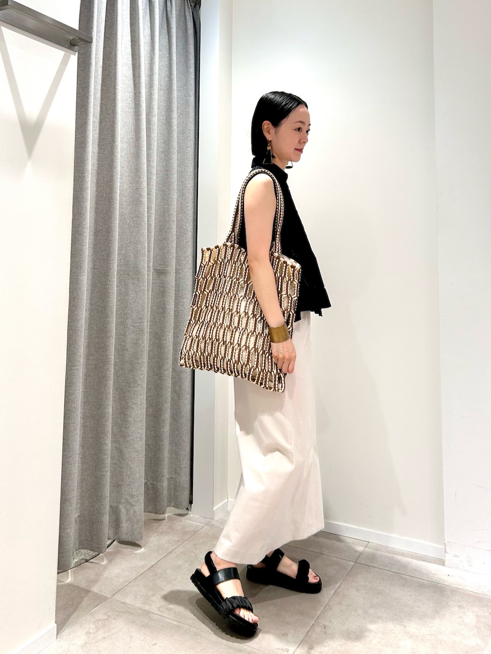 ブラック系のシャツ/ブラウス、ホワイト系のスカート、ブラウン系のトートバッグを着用したレディースの夏コーディネートの5枚目の写真