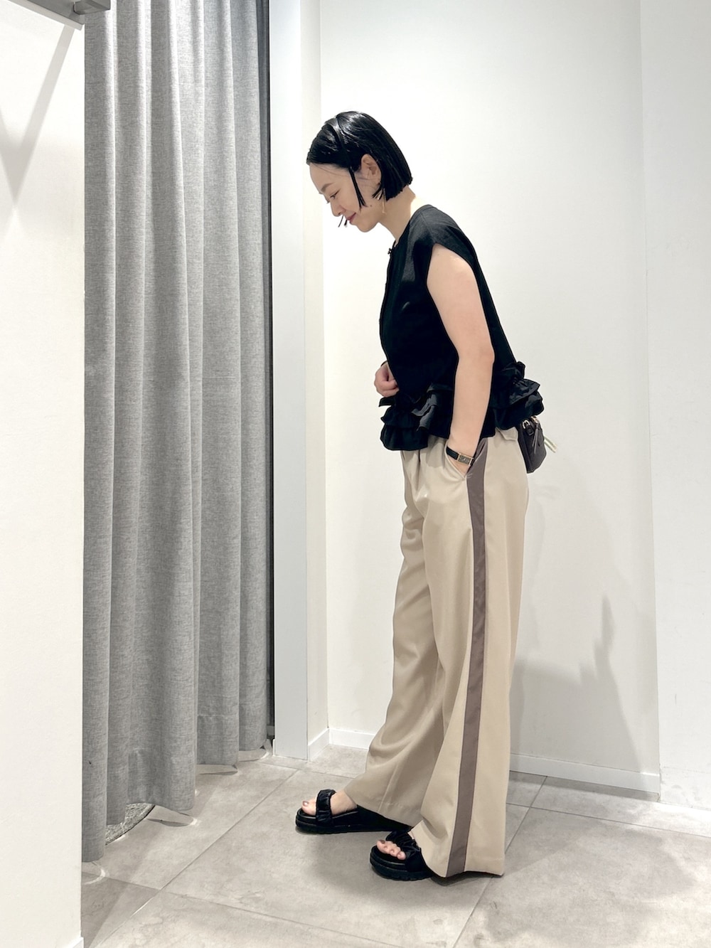 ベージュ系のその他パンツ、ブラック系のベストを着用したレディースの夏コーディネートの2枚目の写真