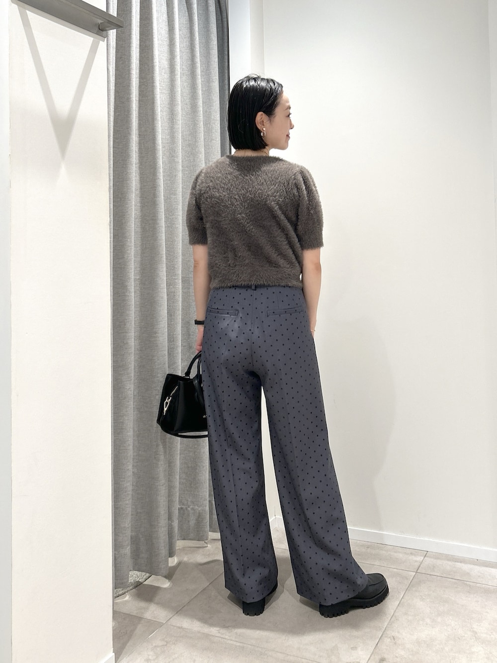 グレー系のその他パンツ、グレー系のニット/セーター、ブラック系のローファーを着用したレディースの夏コーディネートの3枚目の写真