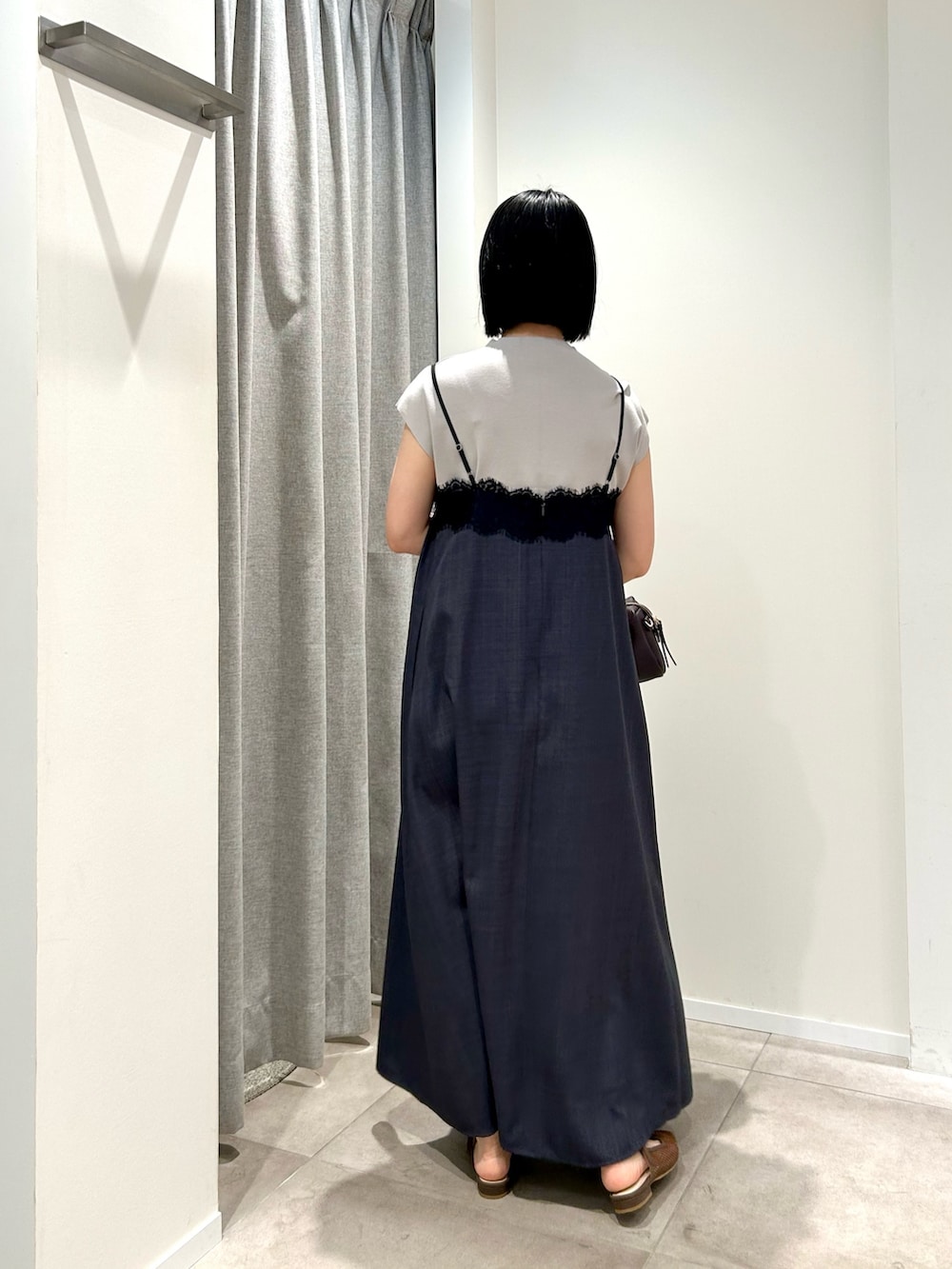グレー系のワンピース、ベージュ系のニット/セーター、ブラウン系のボストンバッグを着用したレディースの夏コーディネートの9枚目の写真