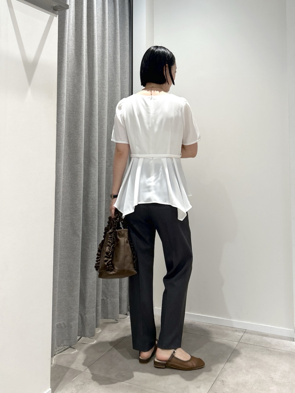 ホワイト系のシャツ/ブラウス、グレー系のその他パンツ、ブラウン系のハンドバッグを着用したレディースの夏コーディネートの4枚目の写真