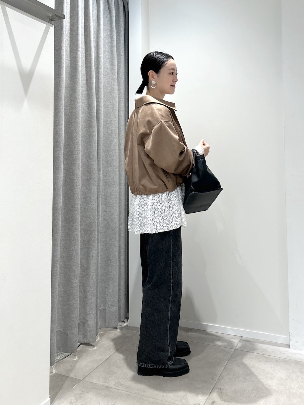 イエロー系のブルゾン、ホワイト系のTシャツ/カットソー、ブラック系のデニムパンツを着用したレディースの秋コーディネートの2枚目の写真