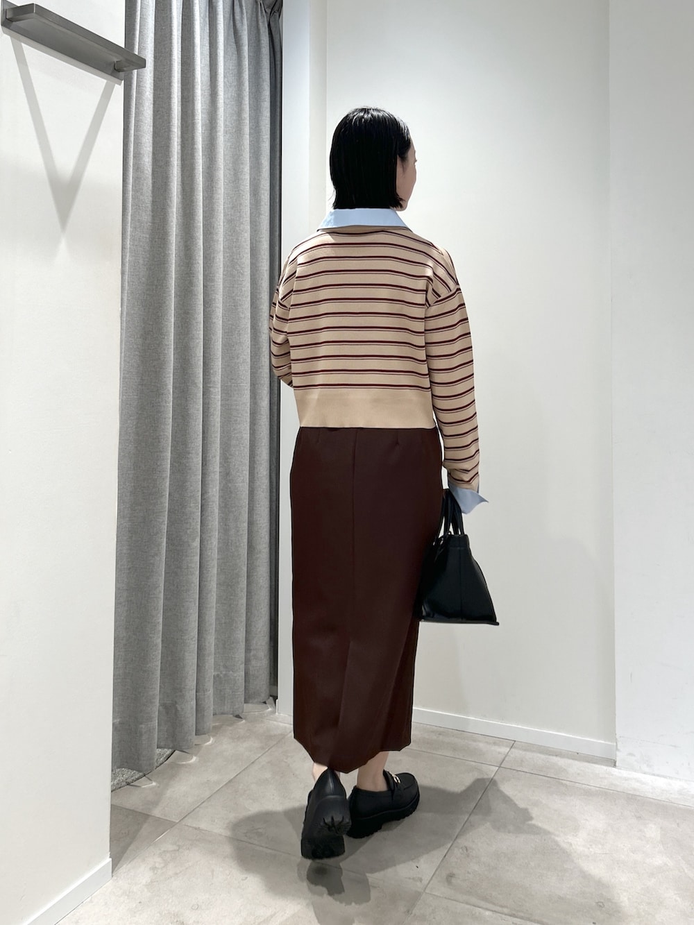 ベージュ系のニット/セーター、ブラウン系のスカート、ブラック系のトートバッグを着用したレディースの夏コーディネートの4枚目の写真