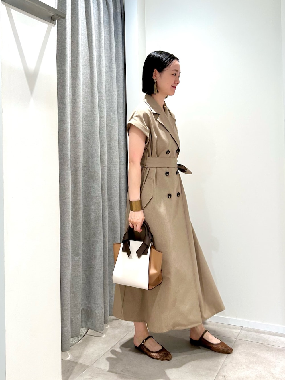 ベージュ系のワンピース、ホワイト系のトートバッグ、ブラウン系のサンダルを着用したレディースの夏コーディネートの2枚目の写真