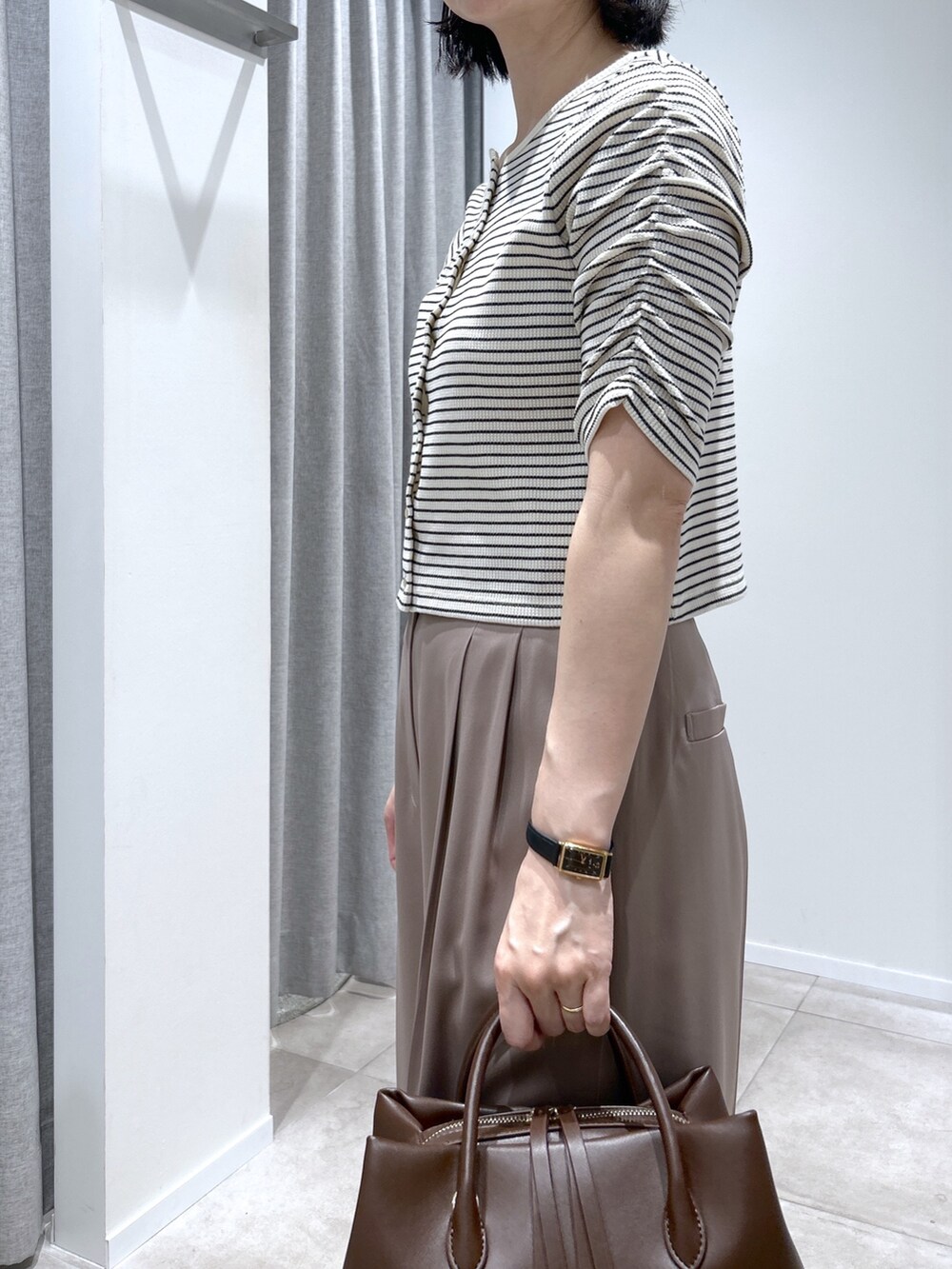 ベージュ系のその他パンツ、ホワイト系のTシャツ/カットソー、ブラウン系のボストンバッグを着用したレディースの夏コーディネートの3枚目の写真