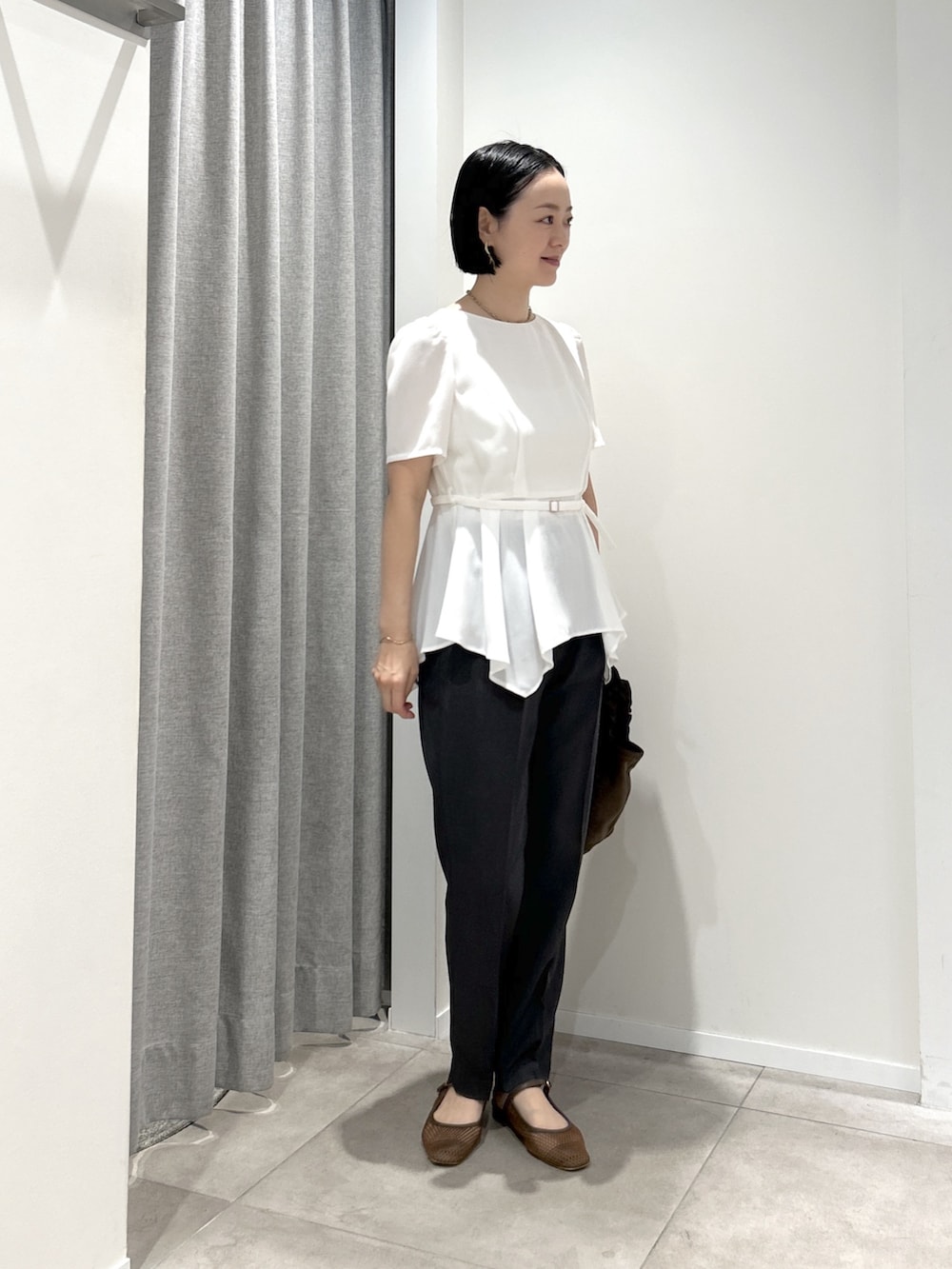 ホワイト系のシャツ/ブラウス、グレー系のその他パンツ、ブラウン系のハンドバッグを着用したレディースの夏コーディネートの3枚目の写真