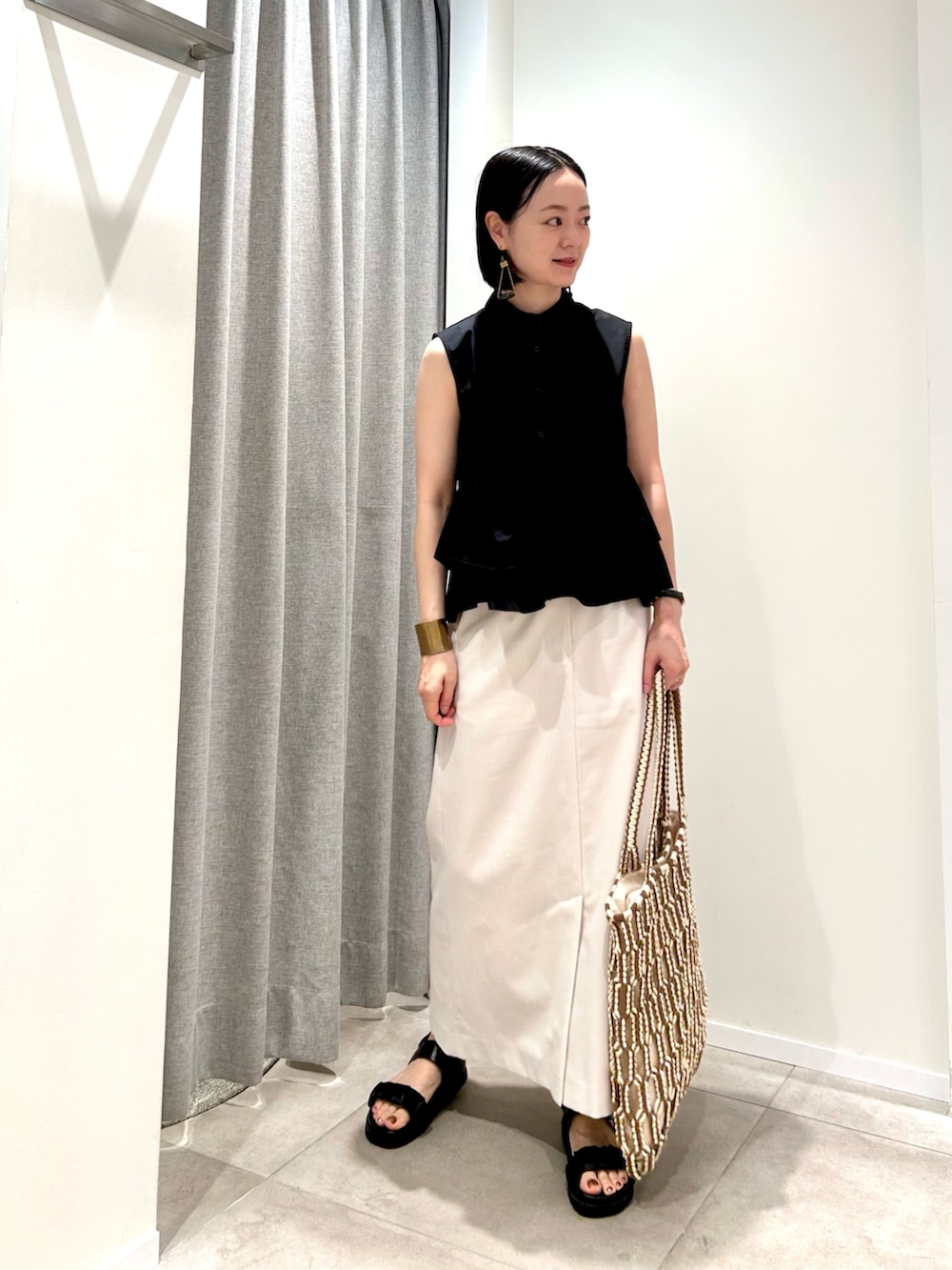 ブラック系のシャツ/ブラウス、ホワイト系のスカート、ブラウン系のトートバッグを着用したレディースの夏コーディネートの6枚目の写真