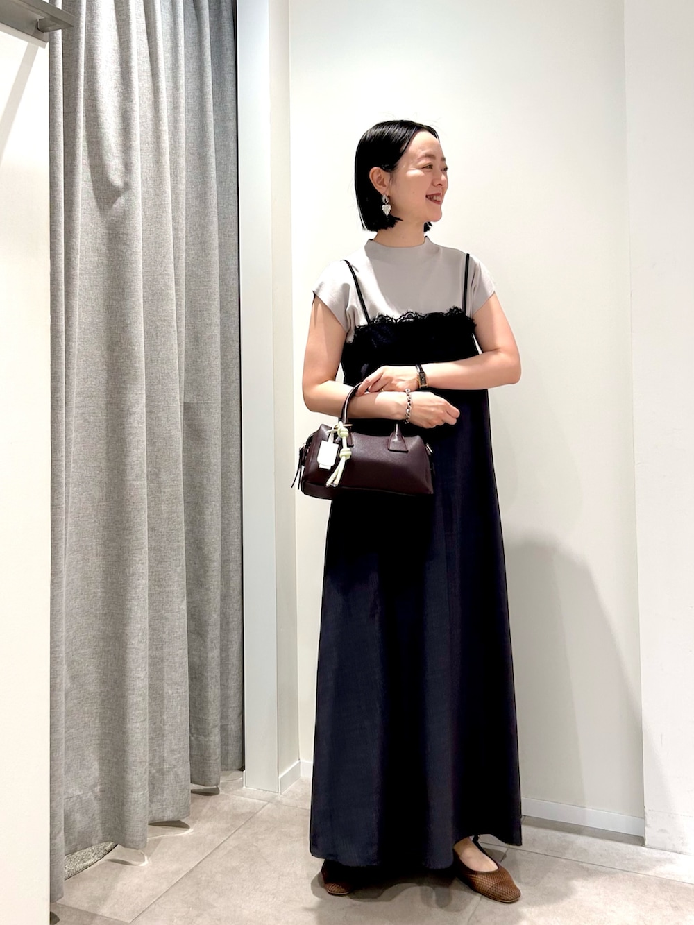 グレー系のワンピース、ベージュ系のニット/セーター、ブラウン系のボストンバッグを着用したレディースの夏コーディネートの4枚目の写真