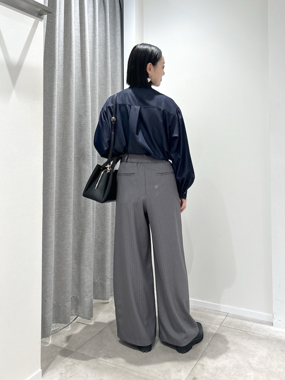 グレー系のその他パンツ、ブルー系のシャツ/ブラウス、ブラック系のトートバッグを着用したレディースの秋コーディネートの4枚目の写真